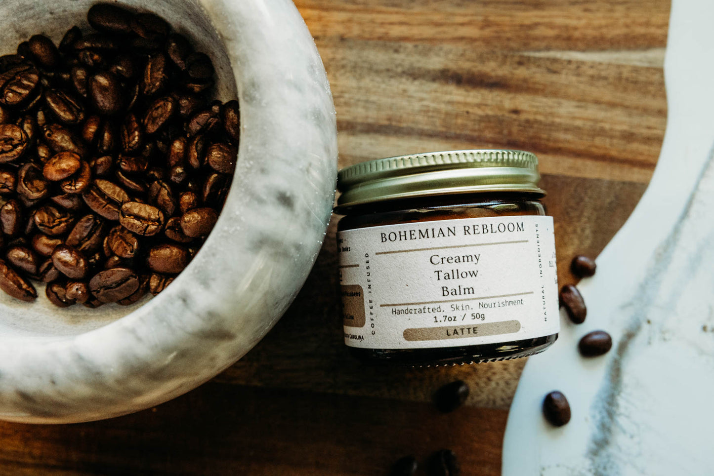 Jar of Bohemian Rebloom Creamy Tallow Balm on a wooden surface with coffee beans.