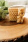 Bar of soap with honeycomb design on a wooden surface