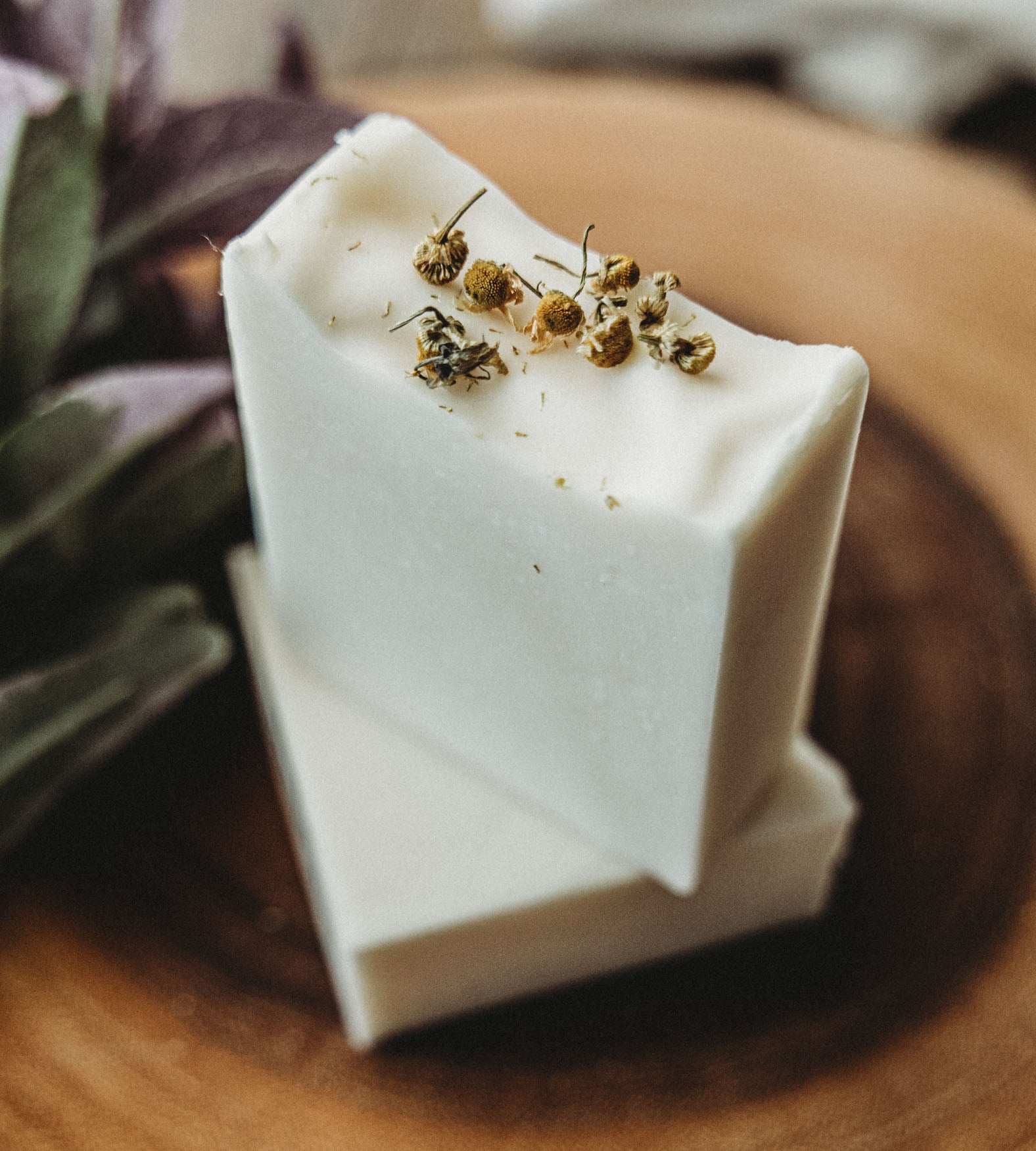Two bars of chamomile lavender soap with Bohemian Rebloom label on a wooden board with dried lavender flowers.