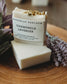 Two bars of chamomile lavender soap with Bohemian Rebloom label on a wooden board with dried lavender flowers.