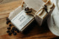 Latte scrub soap bar with coffee beans on a wooden surface