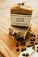 Bohemian Rebirth Latte Scrub soap bar with coffee beans on a wooden surface