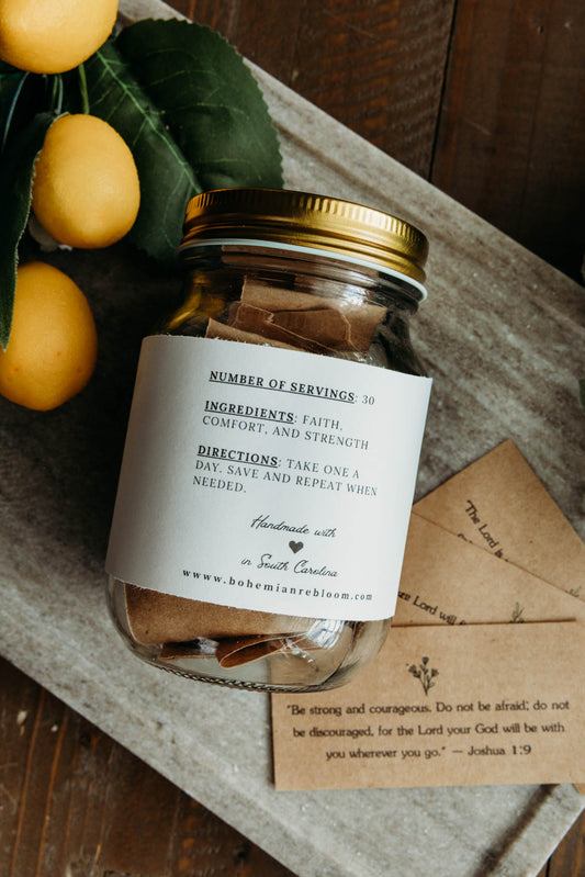 Jar with a label on a wooden surface with lemons and an cards with inspirational Bible versus and scriptures.