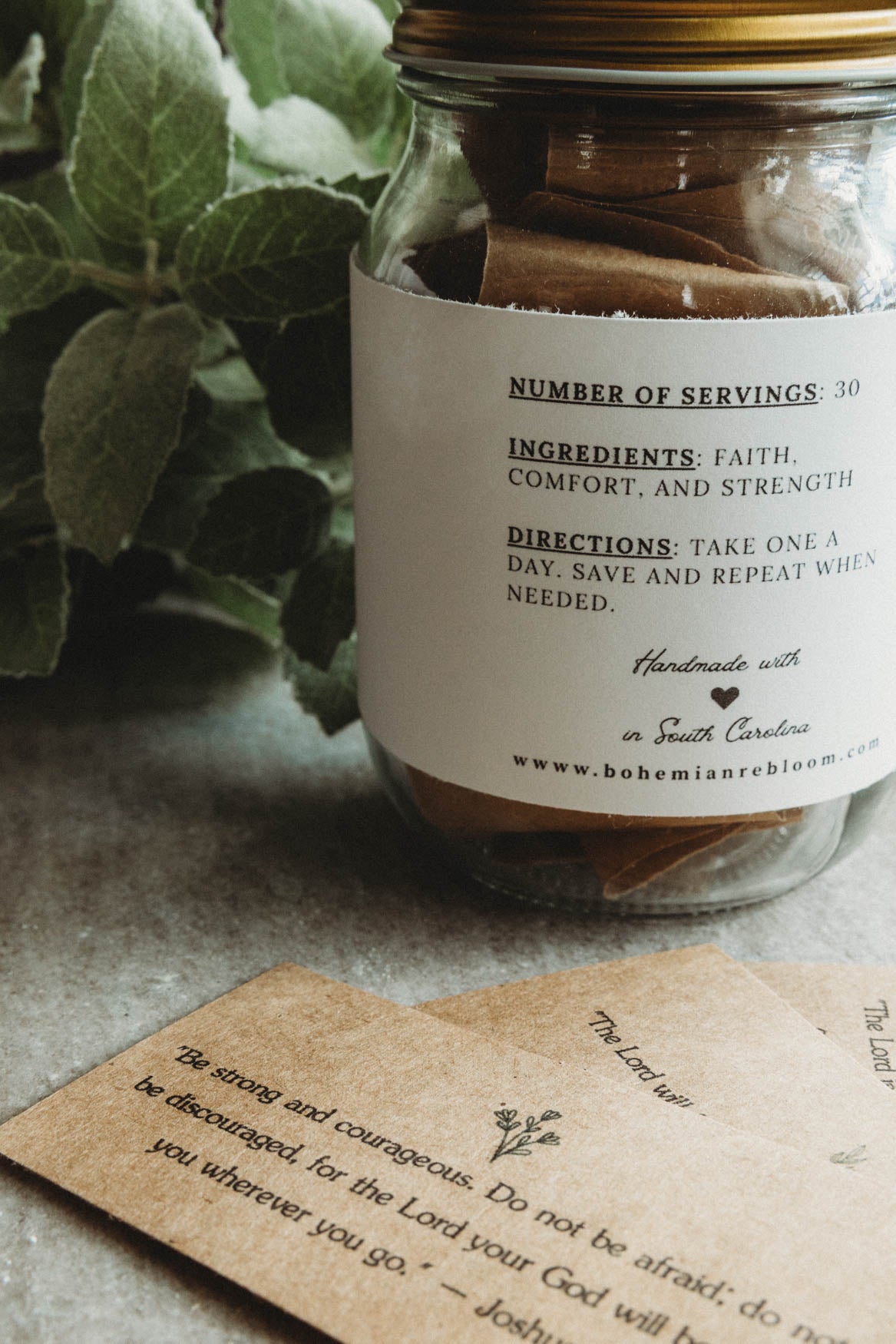 Hug in A Jar with inspirational Bible verses on cardstock paper and greenery in the background.