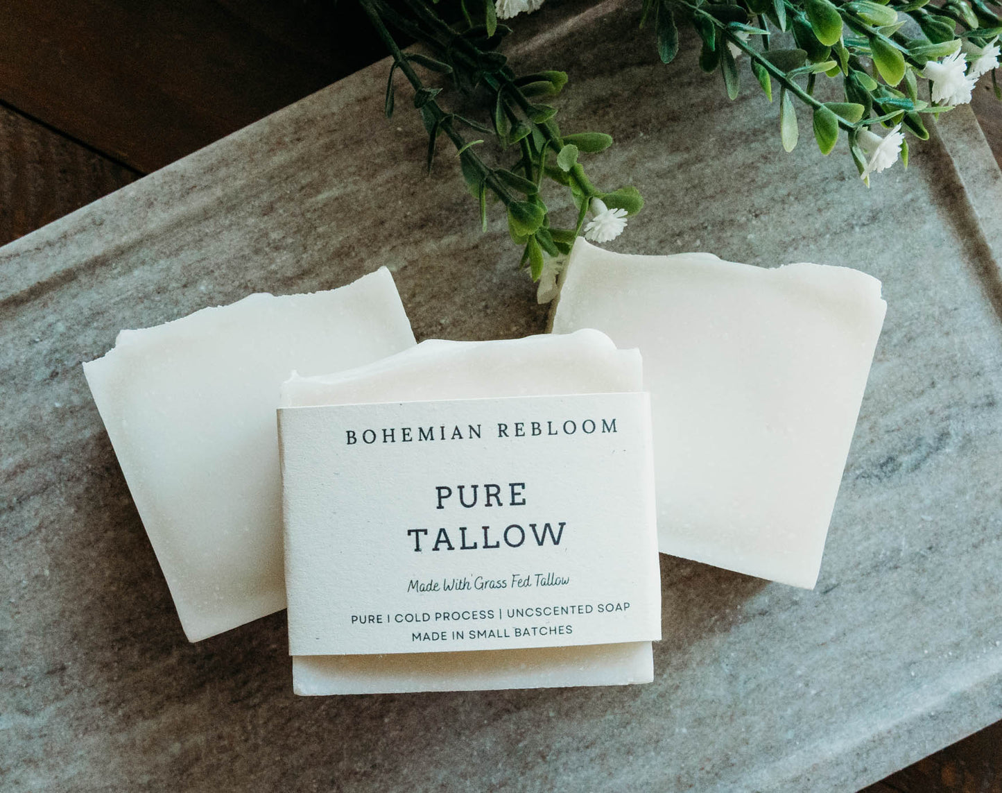 Bohemian Rebloom Pure Tallow soap on a stone surface with greenery in the background