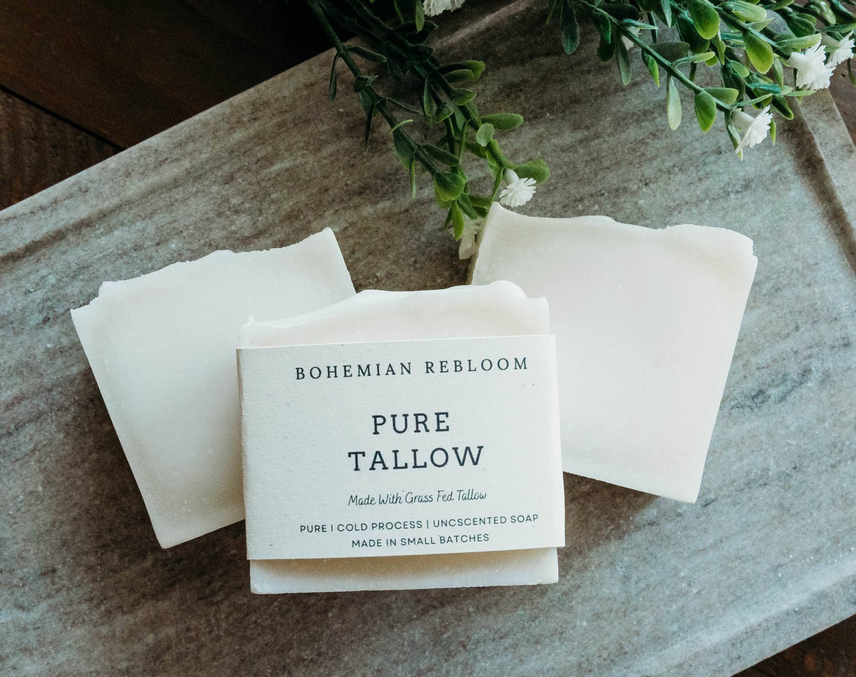 Bohemian Rebloom Pure Tallow soap on a stone surface with greenery in the background