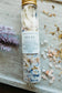 Bath salt test tube labeled Relax with floral and salt on top of marble cutting board.