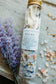 Bath salt product with lavender and flowers on a textured surface