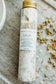 Bath soak bottle labeled 'Calm' on a stone surface with dried flowers.
